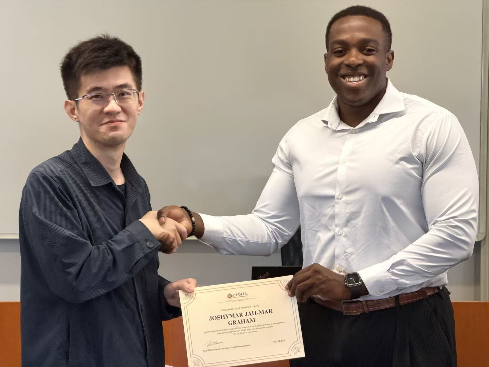 Receiving my certificate from the Doing Business in China program at Peking University's Guanghua School of Management, May 2026.